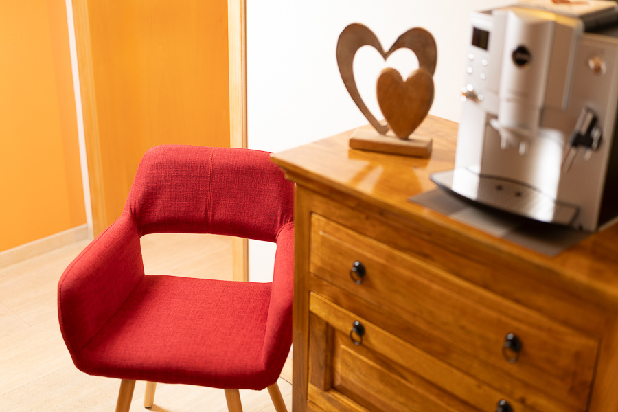 Wartebereich der Physiotherapie-Praxis von Bernhard Wilka mit Stuhl und Kaffeemaschine.